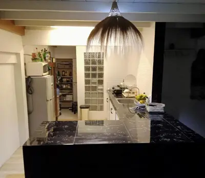 a kitchen with a black counter top and a refrigerator at Shray Villa. Legian in Legian