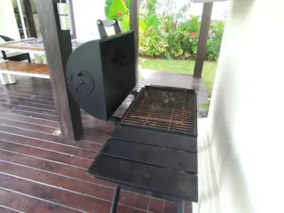a grill on a porch with a table and chairs at Villa Mertasari 10C 4 Bedroom with Swimming pool! in Sanur