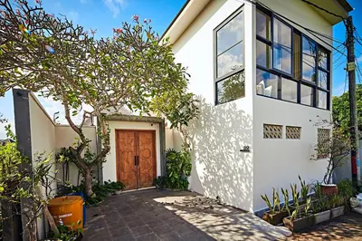 a white house with a wooden door at MASARA Villa - 5Min to Canggu - 2Min to Shops & Restaurants in Canggu