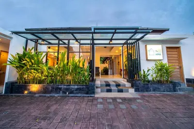a house with a glass door and some plants at Little Boutique Hotel 106- 30m from beach in Canggu