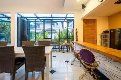 a kitchen and dining room with a counter and chairs at Little Boutique Hotel 102 - 30m from beach in Canggu