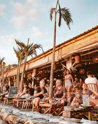 a group of people sitting outside of a restaurant at Little Boutique Hotel 107- 30m from beach in Canggu