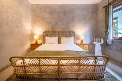 a bedroom with a bed and two lamps on tables at Little Boutique Hotel 108- 30m from beach in Canggu