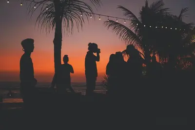 a silhouette of a wedding party on the beach at sunset at Little Boutique Hotel 108- 30m from beach in Canggu