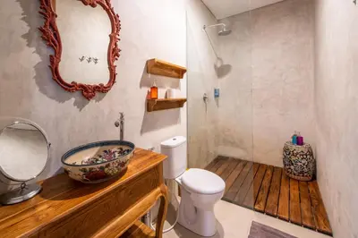 a bathroom with a sink and a toilet and a mirror at Little Boutique Hotel 108- 30m from beach in Canggu