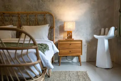 a bedroom with a bed and a lamp on a night stand at Little Boutique Hotel 108- 30m from beach in Canggu
