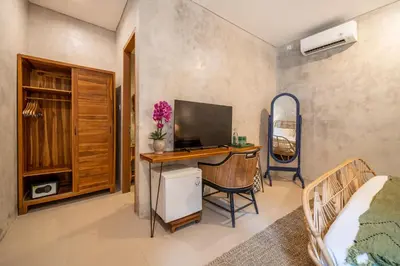 a bedroom with a desk with a computer and a bed at Little Boutique Hotel 108- 30m from beach in Canggu