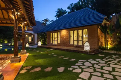 a house with a lawn in front of a building at Sunset Paradise Villa Nusa Dua in Nusa Dua