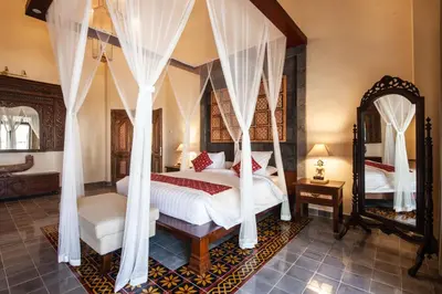 a bedroom with a canopy bed and a mirror at Sunset Paradise Villa Nusa Dua in Nusa Dua