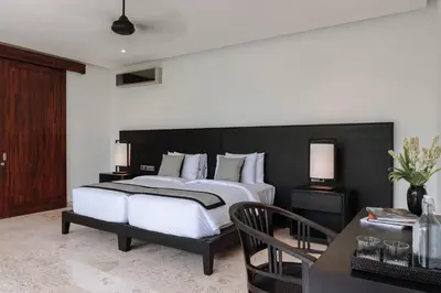 a bedroom with a large bed with a black headboard at Villa Amara Pradi - 550m to Petitenget Beach in Seminyak