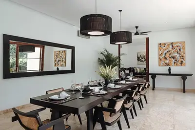 a dining room with a table and chairs and a mirror at Villa Amara Pradi - 550m to Petitenget Beach in Seminyak