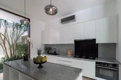 a kitchen with white cabinets and a counter top at Villa Amara Pradi - 550m to Petitenget Beach in Seminyak