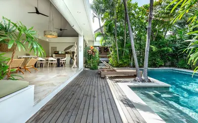 a house with a swimming pool and a dining area at Villa Gallici Seminyak in Seminyak