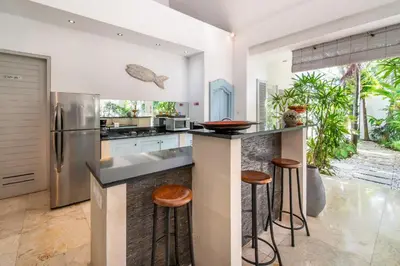 a kitchen with a island with bar stools at Villa Gallici Seminyak in Seminyak