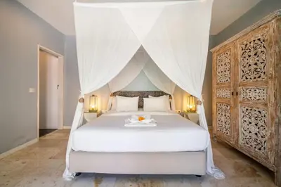 a bedroom with a white bed with a canopy at Villa Gallici Seminyak in Seminyak