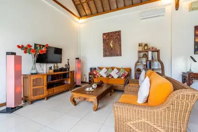 a living room with two couches and a tv at Taman Rahasia by iBali Management in Kerobokan