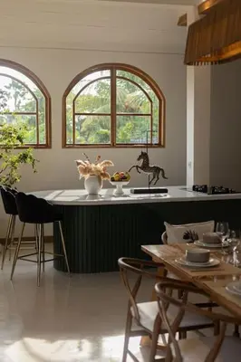a kitchen with a table and chairs and two windows at Villa Kanopi Luxurious 3BR Villa with Pool and Quick Beach Access in Canggu