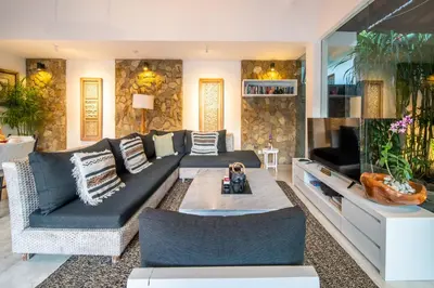 a living room with a couch and a tv at Lotus Luxury Villa Seminyak in Seminyak