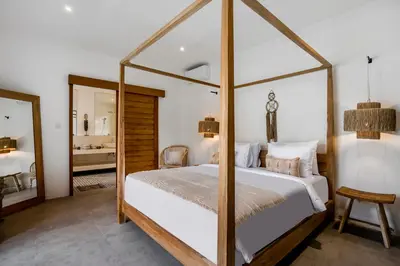 a bedroom with a four poster bed and a mirror at Villa Mimpi Seminyak by Alfred in Bali in Seminyak
