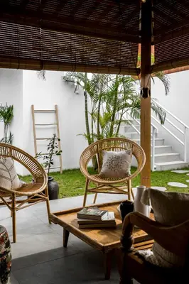 a patio with two chairs and a coffee table at Villa Mimpi Seminyak by Alfred in Bali in Seminyak