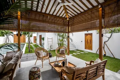 an outdoor living room with a wooden pergola at Villa Mimpi Seminyak by Alfred in Bali in Seminyak