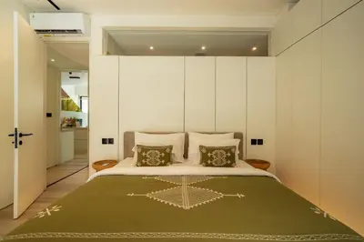 a bedroom with a large bed with white walls at Oasis Villa 8 by Betterplace in Canggu