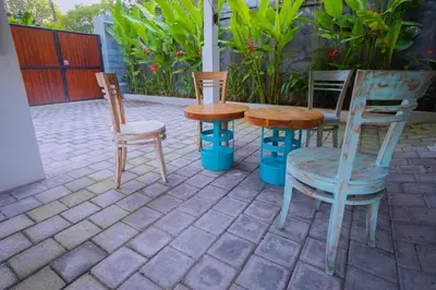 three chairs and a table and chairs on a patio at Kos Bulan Bali in Kuta