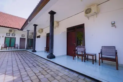 a courtyard of a house with chairs and a door at Kos Bulan Bali in Kuta