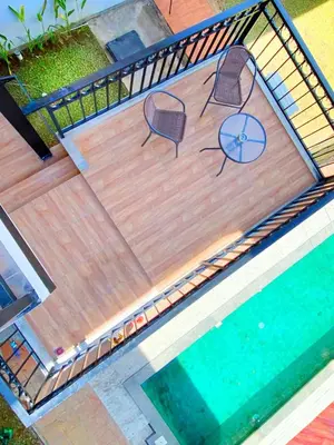 two chairs and a table next to a swimming pool at PAMELA BALI in Kerobokan