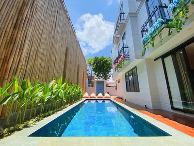 a swimming pool in front of a building at PAMELA BALI in Kerobokan