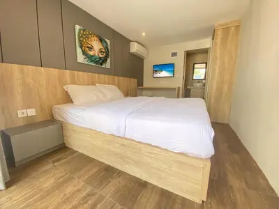 a bedroom with a large bed with white sheets at PAMELA BALI in Kerobokan