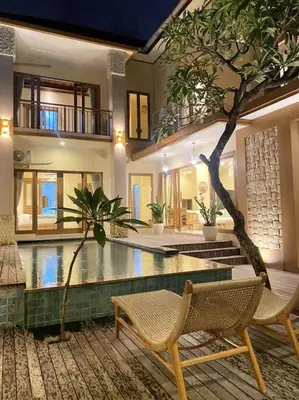 a pool in a house with two chairs and a tree at Cozy 3 Bedroom Villa in Seminyak in Seminyak