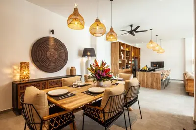 a dining room with a wooden table and chairs at Zayana Villas Resort Seminyak in Seminyak