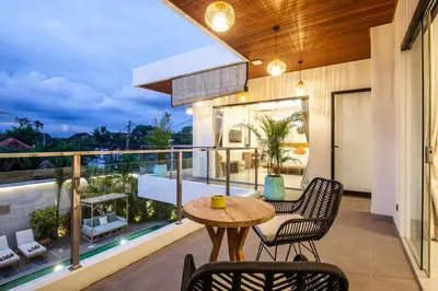 a patio with a table and chairs on a balcony at Zayana Villas Resort Seminyak in Seminyak
