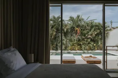 a bedroom with a bed and a view of a pool at Designer 3BR Villa Tropical Stay Near Canggu in Kerobokan