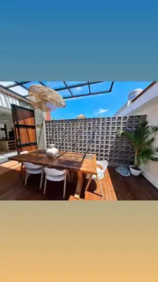 a wooden table and chairs on a wooden deck at Villa Anoli - 3 chambres - Centre de Seminyak in Seminyak
