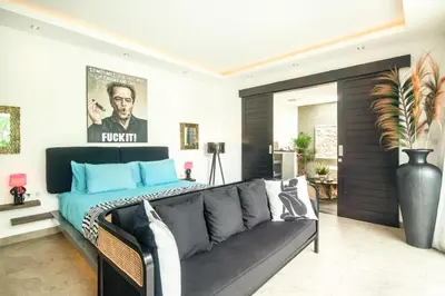 a living room with a couch and a poster on the wall at Splendid Villa 3Br 200m to the Brawah beach in Canggu