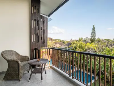 a balcony with a table and chairs and a view at Cove Tevana in Seminyak