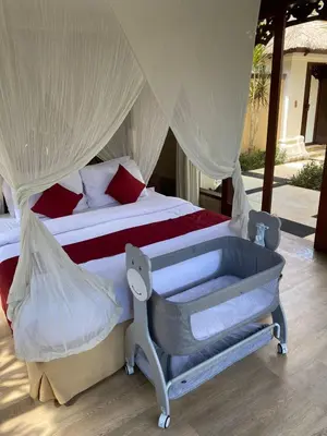 a bedroom with a bed with a mosquito net at Jimbaran BeachStroll Villa (2BR) in Jimbaran