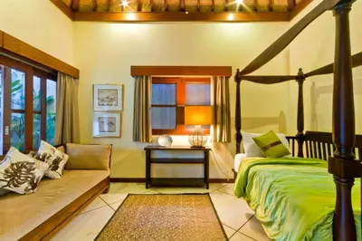 a bedroom with a bed and a couch and a window at Villa Mango - 3 Bedroom Villa in Seminyak in Seminyak