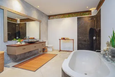 a bathroom with a tub and a sink and a shower at Villa Elyse Seminyak in Seminyak