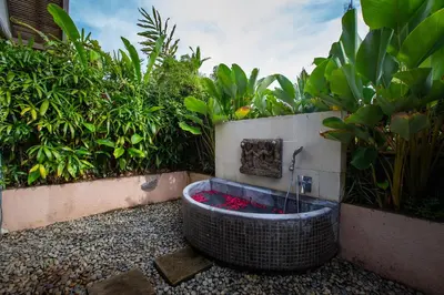 a bath tub sitting in the middle of a garden at Villa Elyse Seminyak in Seminyak