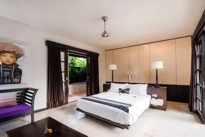 a bedroom with a large bed and a couch at Villa Spirit 4 BR - Canggu in Canggu