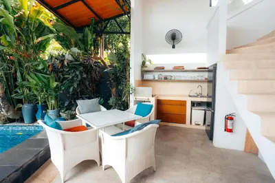 an outdoor kitchen and dining area with a table and chairs at Bali Adua Villa in Seminyak