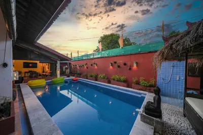 a swimming pool in a house with a sunset in the background at Huge 2 Bedroom private pool Villa - Gong Zhu Camille in Pesanggaran