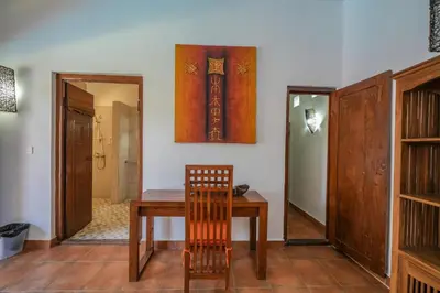a dining room with a wooden table and a mirror at Huge 2 Bedroom private pool Villa - Gong Zhu Camille in Pesanggaran