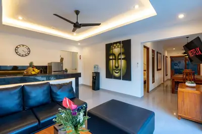 a living room with a couch and a clock on the wall at Vast 5bd Villa with Garden and Private Pool 250m to Beach in Seminyak