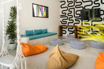 a living room with orange and blue pillows at SHAKA CLAN SURF in Canggu