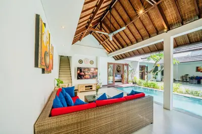 a living room with a couch and a swimming pool at Villa Olli in Seminyak
