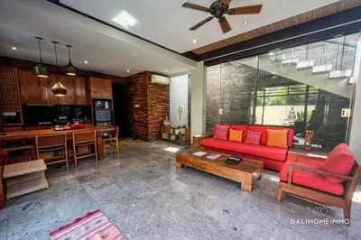 a living room with a red couch and a table at Villa Canthy@Seminyak in Seminyak